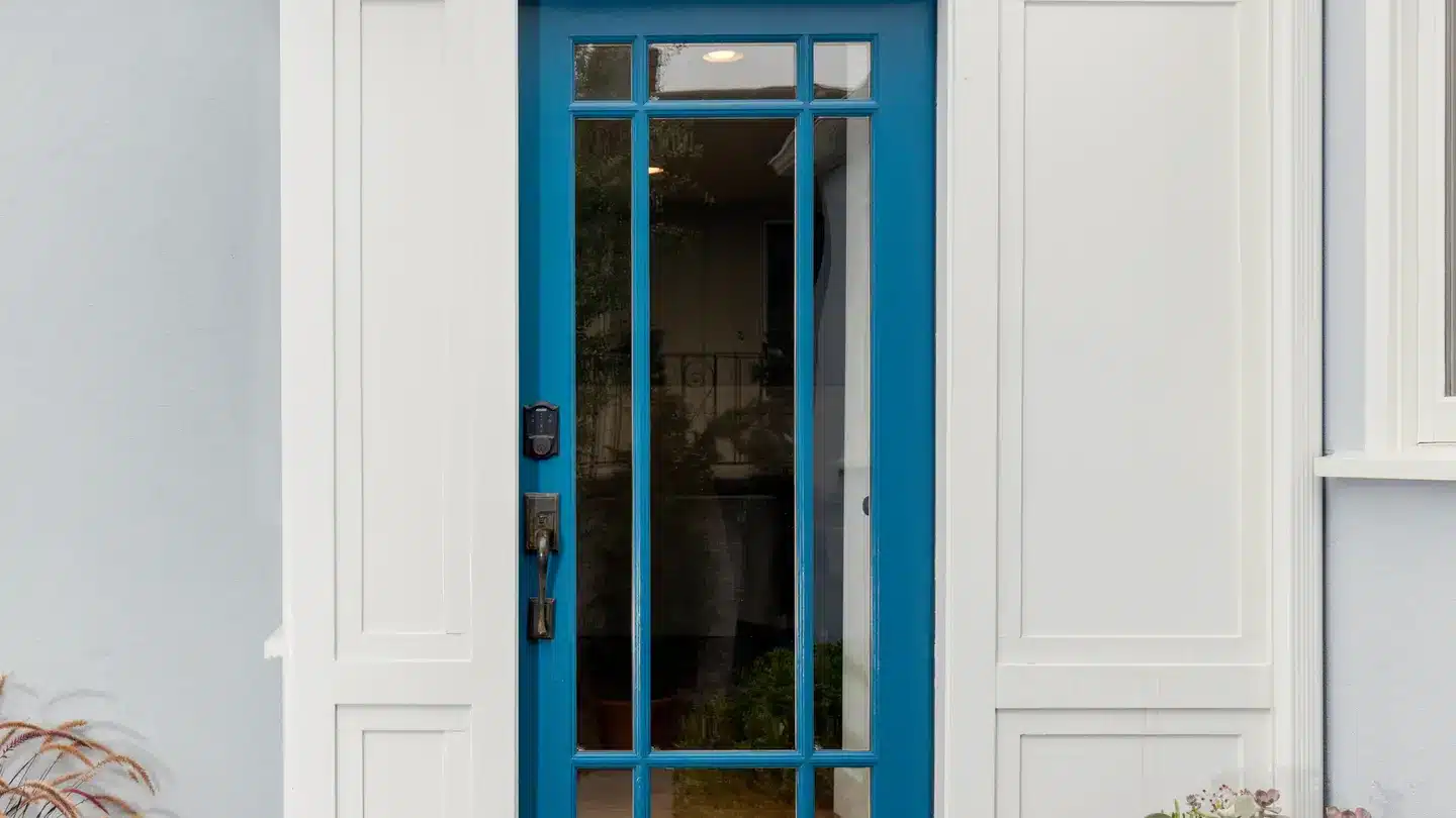 Blue fiberglass door with iron finishes and white trim.