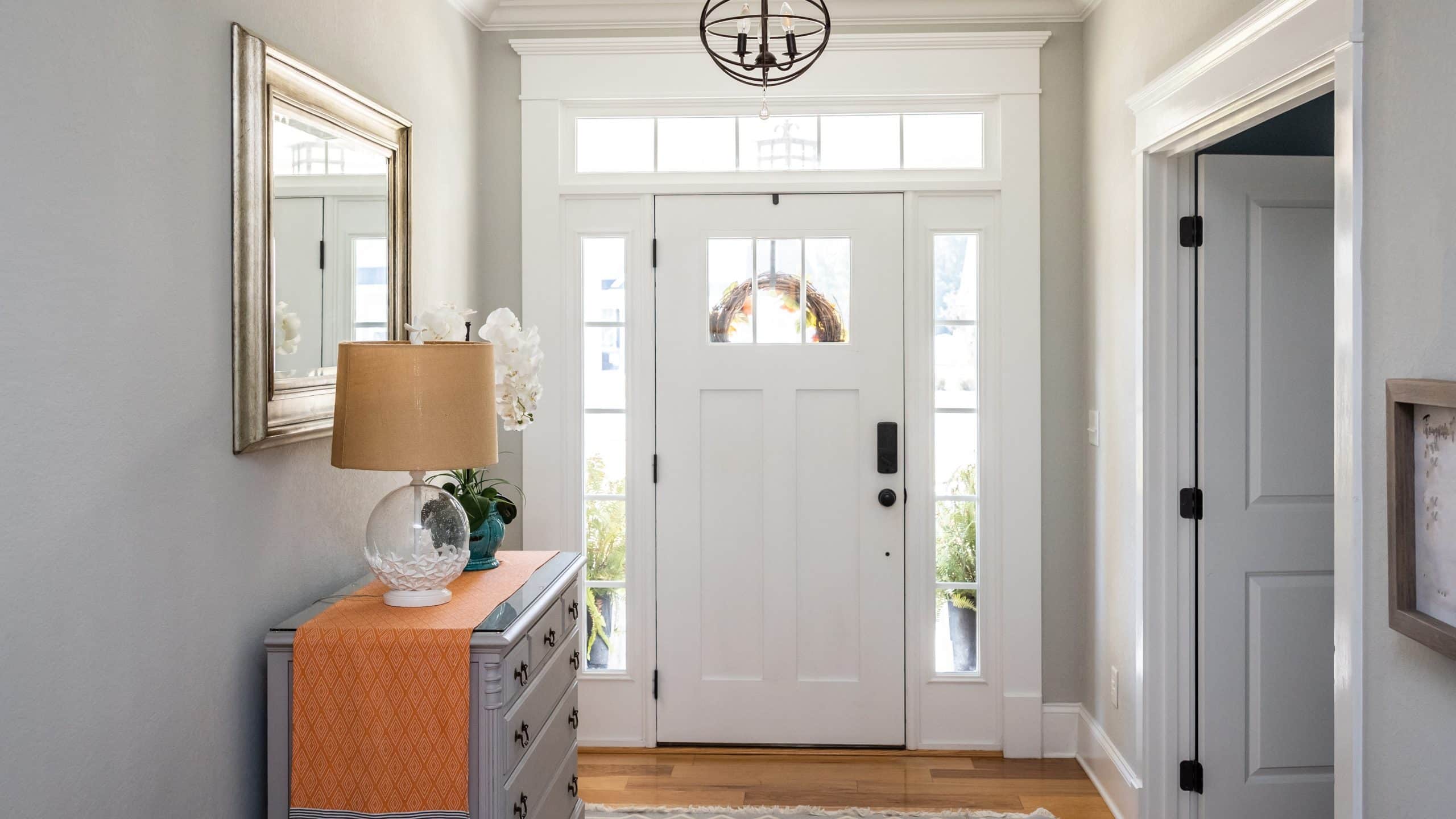 Interior view of a white entry door with sidelights and a transom